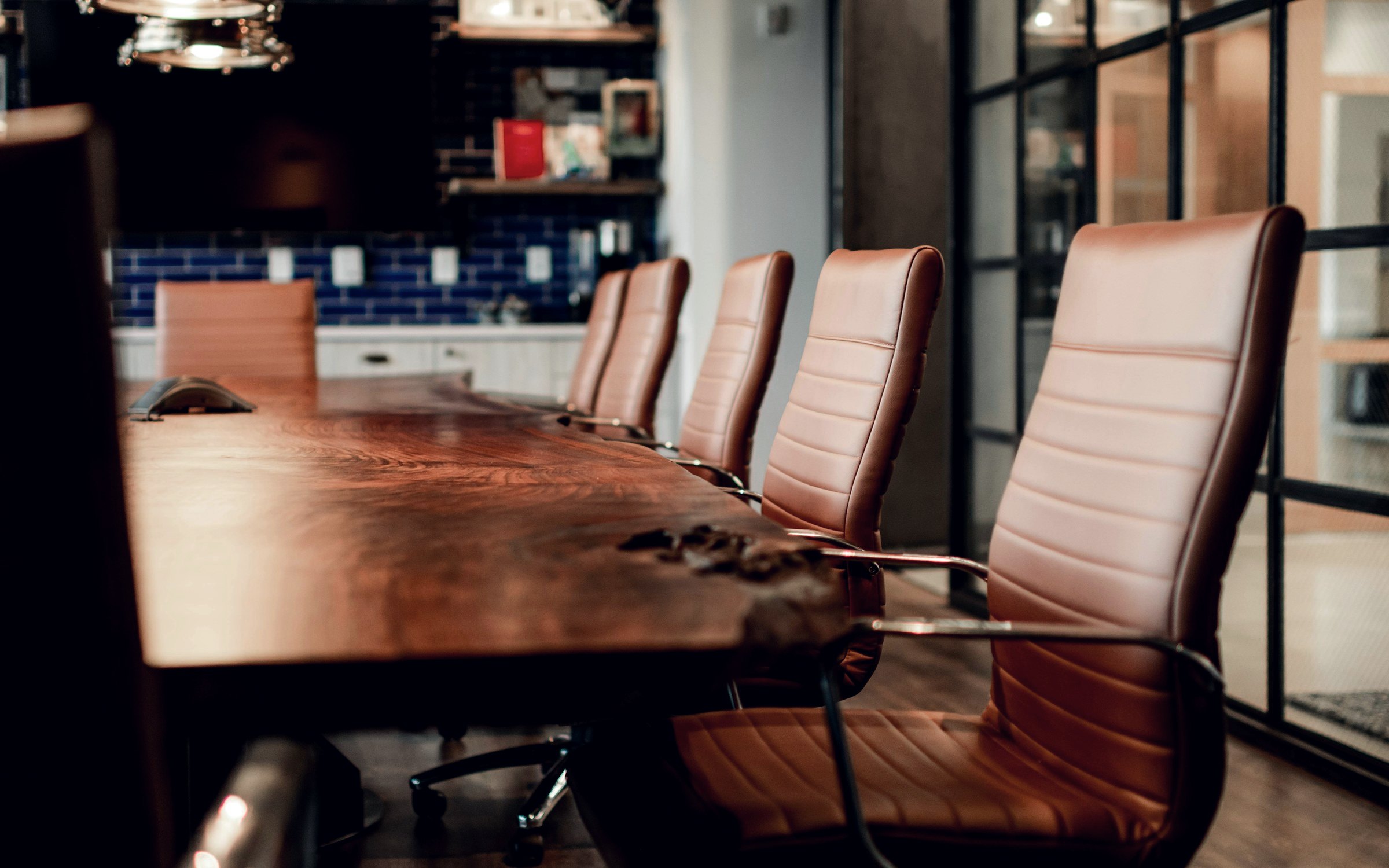 Empty boardroom with leather chairs along a long table