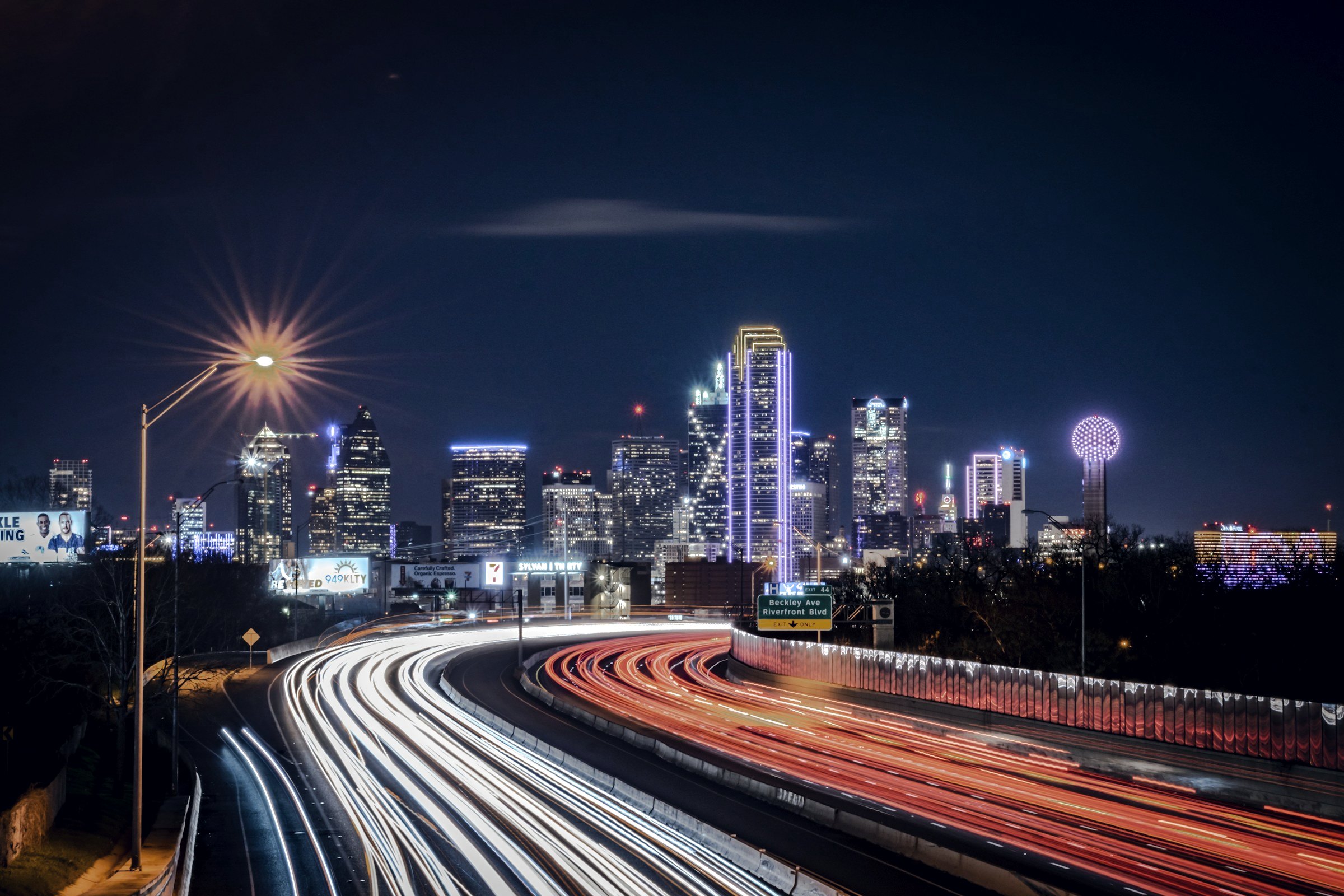 Dallas skyline at night with light trails on a highway