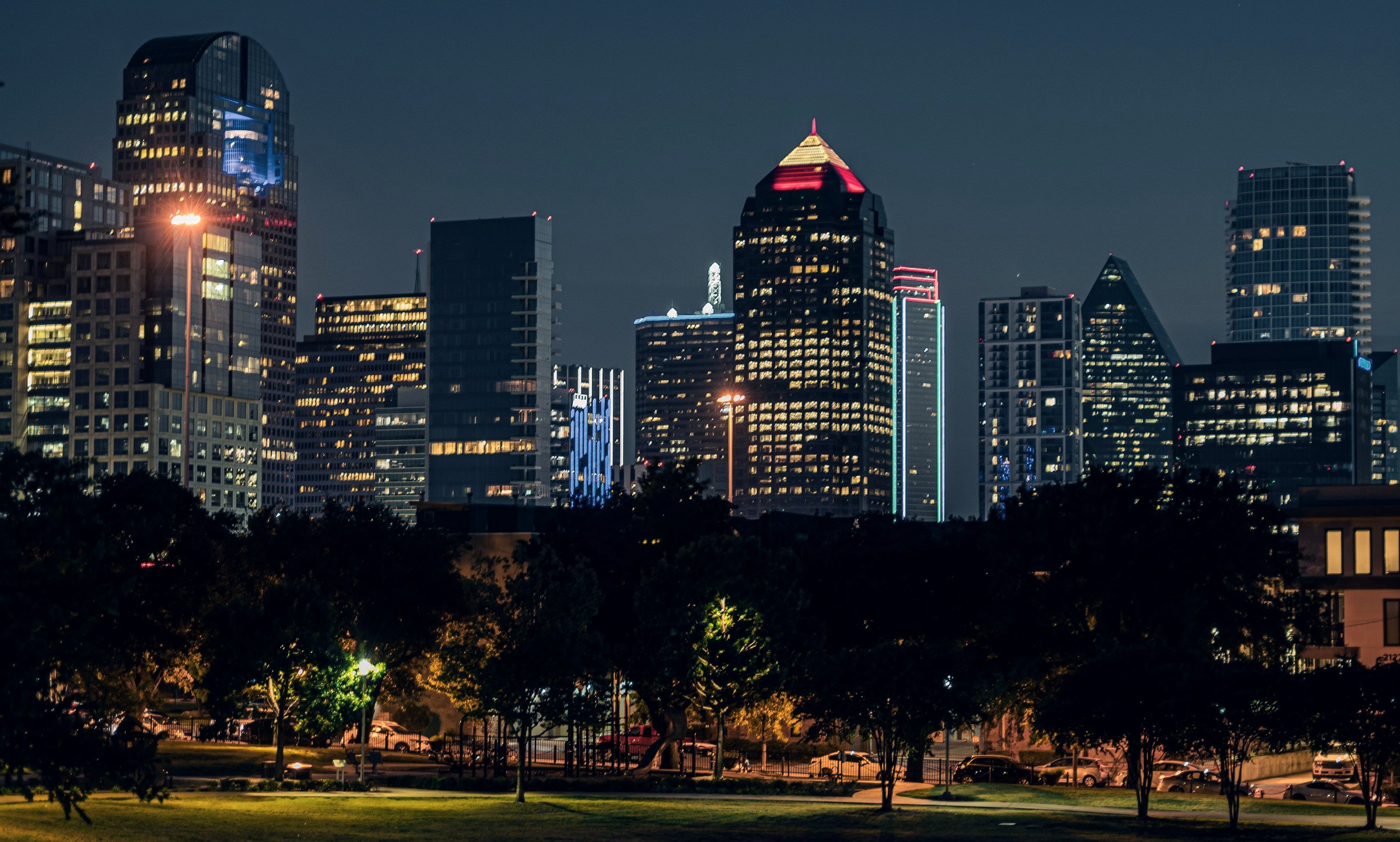 City skyline at night above a lit park